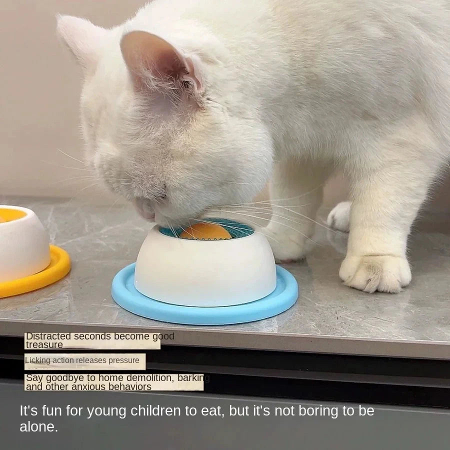 Gato blanco lamiendo el juguete apoyado en la mesa