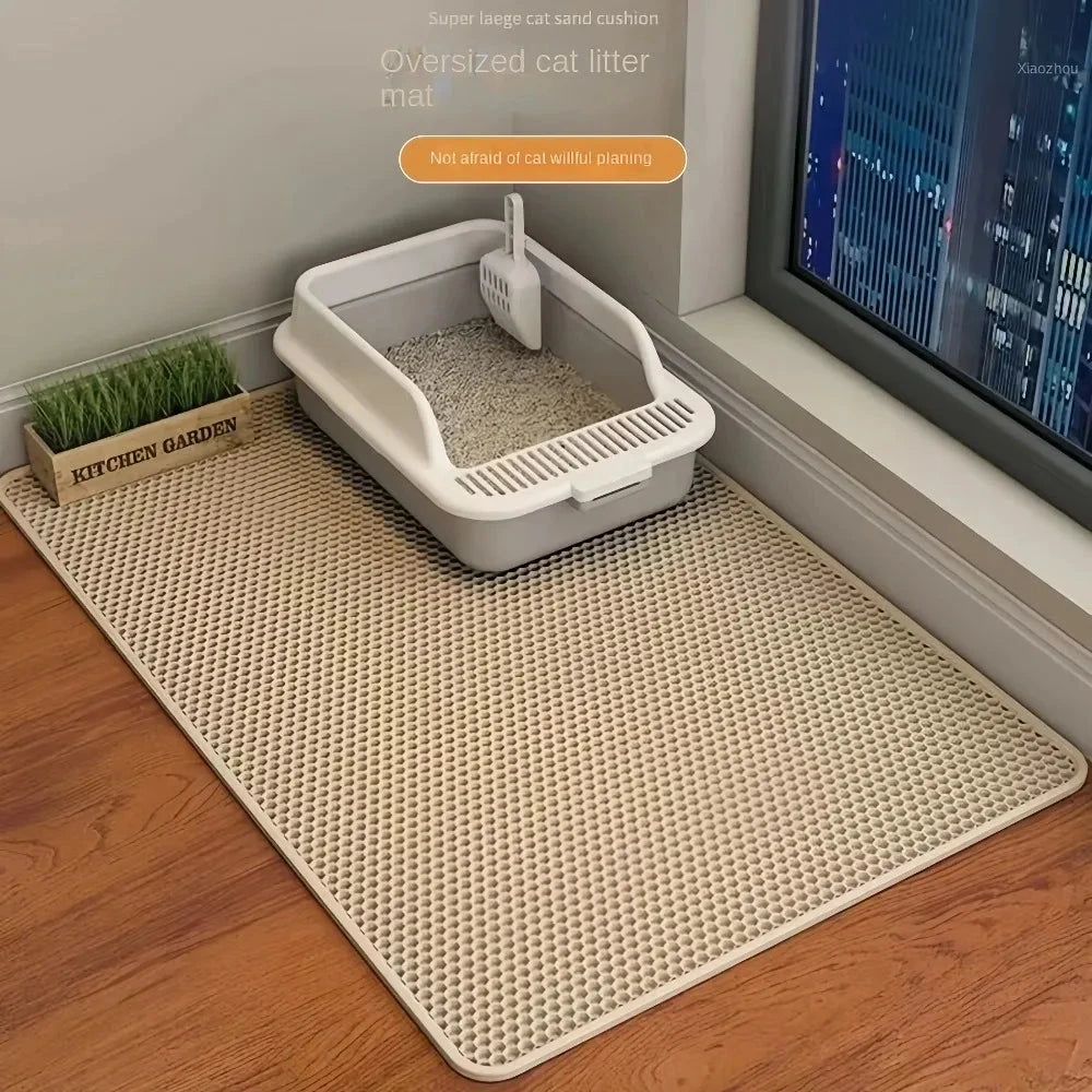 La alfombra atrapa-arena gris bajo el arenero, sobre suelo de madera