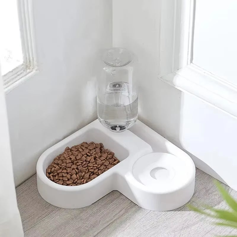 Comedero de esquina con la botella de agua puesta, en el suelo de una habitación