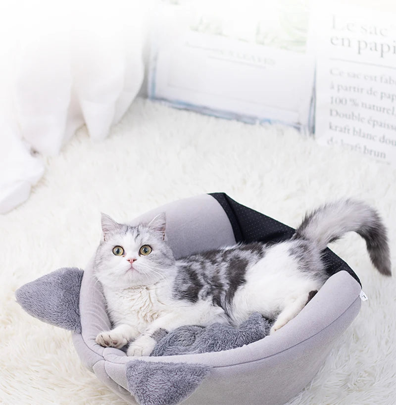 La misma cama con la capucha bajada, convertida en cama abierta con un gato tumbado