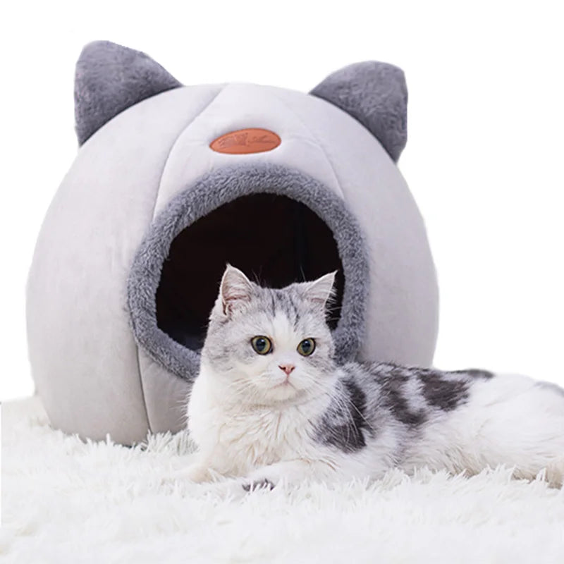 Cama cueva con forma de gato AMIKART en gris claro, con un gato descansando dentro